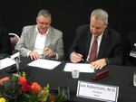 OHSU President Joe Robertson and Adventist's chief Bill Wing sign a deal to affiliate.