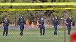 Law enforcement crews search the field behind Silver Rail Elementary School, in Bend, Ore., Oct. 15, 2026. 