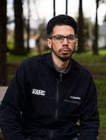 A man wears a Columbia Sportswear light fleece jacket and glasses in a park.