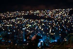 A woman takes a photo of the first blood moon lunar eclipse of the year at the Killi Killi lookout in La Paz, Bolivia, Sunday, May 15, 2022. (AP Photo/Juan Karita)