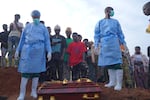 People dressed in protective gear prepare to lower into a grave the coffin containing the remains of 3-year-old Mave Mercienne, who died of Ebola, in Bunia, Ituri province, eastern Congo, Tuesday, Aug. 18, 2026.