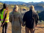 KRRC's Ren Brownell and Karuk Tribal members Lisa Morehead-Hillman and Leaf Hillman watch as the first scoops of soil are removed from Iron Gate dam.