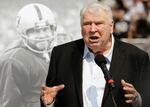 FILE - Former Oakland Raiders head coach John Madden speaks about former quarterback Ken Stabler, pictured at rear, at a ceremony honoring Stabler during halftime of an NFL football game between the Raiders and the Cincinnati Bengals in Oakland, Calif., on Sept. 13, 2015.