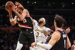 Portland Trail Blazers forward Toumani Camara, left, catches a rebound against Los Angeles Lakers forward Anthony Davis, center, during the first half of an NBA basketball game, Sunday, Dec. 8, 2024, in Los Angeles.