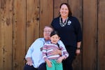 Jen Proctor Andrews, vice-chair of the Coquille Indian Tribe, stands with her mother, Linda Mecum, and 5-year-old son, Dexter. The two women have fought for restoration and cultural preservation, creating an environment in which Dexter can grow up immersed in his Coquille culture. He is one of the first kids in generations to grow up speaking his native language, Miluk.