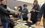 The Y's spokesperson, Beth Casper (left), holds a panoramic photo of Eugene as others examine the time capsule's material from 1955 and 1909.