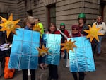 Supporters of two resolutions opposing fossil fuel projects dressed up and danced outside Portland City Hall Wednesday.