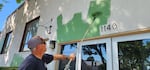 A volunteer paints a building in downtown Sweet Home, Oregon.