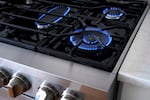 Flames erupt from the burners of a natural gas stove, Wednesday, June 21, 2023, in Walpole, Massachusetts. (AP Photo/Steven Senne)