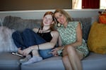 Veronica’s mom, Emily (right), says that before Veronica came out as trans, she already knew. “I was kind of just waiting to hear — I wasn't pushing it, but I just knew.” Emily has medium-length blond hair, and she is sitting close to Veronica on their couch. Veronica has her feet up on the couch and is leaning into her mom.