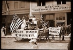 This image, circa 1900, shows a Grants Pass parade float advertising the Rogue River Courier and "talking machines." The Courier newspaper changed names several times over the years.