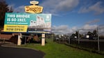 A billboard next to Interstate 5 with cars driving past.