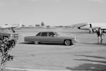 An armored Cadillac car belonging to the U.S. Embassy pulls up to an arriving U.S. government jet plane in Ilopango, El Salvador, in November 1982.