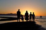 FILE - In this June 13, 2021 file photo, people hold hands as they gather at the receding edge of the Great Salt Lake to watch the sunset near Salt Lake City. The lake has been shrinking for years, and a drought gripping the American West could make this year the worst yet.