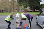 Third grade teacher Jessica Neal helps a parent choose a few books to bring home. Along with laptops, the staff at Rock Creek Elementary in Beaverton provided supplies to help their students continue their lessons while staying at home.