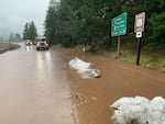 ODOT truck arriving along stretch of highway with water and debris after a landslide