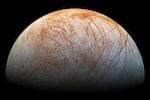 This image released by NASA shows Jupiter's moon Europa with its signature red scars.