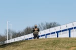 An Immigration and Customs Enforcement worker stands outside a warehouse in Williamsport, Md., that's being converted into an immigration detention center with plans to hold 1,500 people, on March 9.