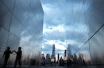 A child walks between the twin parallel walls of Empty Sky, the 9/11 memorial in Jersey City, New Jersey, on August 23. In the background are One World Trade Center and other tall buildings in Lower Manhattan.