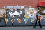 A Minneapolis police officer walks past a mural of George Floyd at the square.