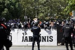 Portland Police in riot gear stand between right-wing protesters and counter-protesters.