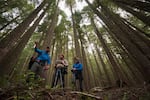 Jared Smith and OPB's Michael Bendixen and Jule Gilfillan scout the landscape around the slot canyon.