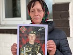 FILE - Olena Balai holds a photo of her only son, Viktor Balai, a 28-year-old veteran of the war, in Zdvyzhivka, Ukraine, April 30, 2022. Olena identified his body in eastern Ukraine's Donbas region, on the forest floor. "His brain was leaking out of his head," she said. "The face and mouth were torn apart, the teeth knocked out. There was no space left alive on his body. What pain he bore."