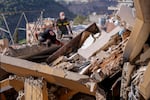 Rescue workers search for victims in the rubble of a destroyed building hit in an Israeli airstrike on Tuesday night, in Barja, Lebanon, Wednesday, Nov. 6, 2024.