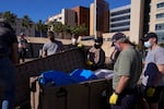 Engineers and volunteers gather around ventilators while setting up a mobile field hospital at UCI Medical Center, Monday, Dec. 21, 2020, in Orange, Calif.