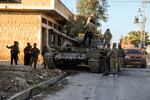 Syrian opposition fighters stand atop a captured Syrian army tank in the town of Maarat al-Numan, southwest of Aleppo, on Saturday.