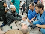 Palestinian medics listen to a man as the wounded are brought to the Kamal Adwan hospital in Beit Lahia following Israeli bombardment on Tuesday. The hospital is situated just a few miles south of the Indonesian hospital, which was hit Monday by Israeli shelling, according to Palestinian officials.
