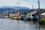 Floodwater inundates homes along a road Wednesday, Nov. 17, 2021, in Sumas, Wash. An atmospheric river—a huge plume of moisture extending over the Pacific and into Washington and Oregon—caused heavy rainfall in recent days, bringing major flooding in the area. (AP Photo/Elaine Thompson)