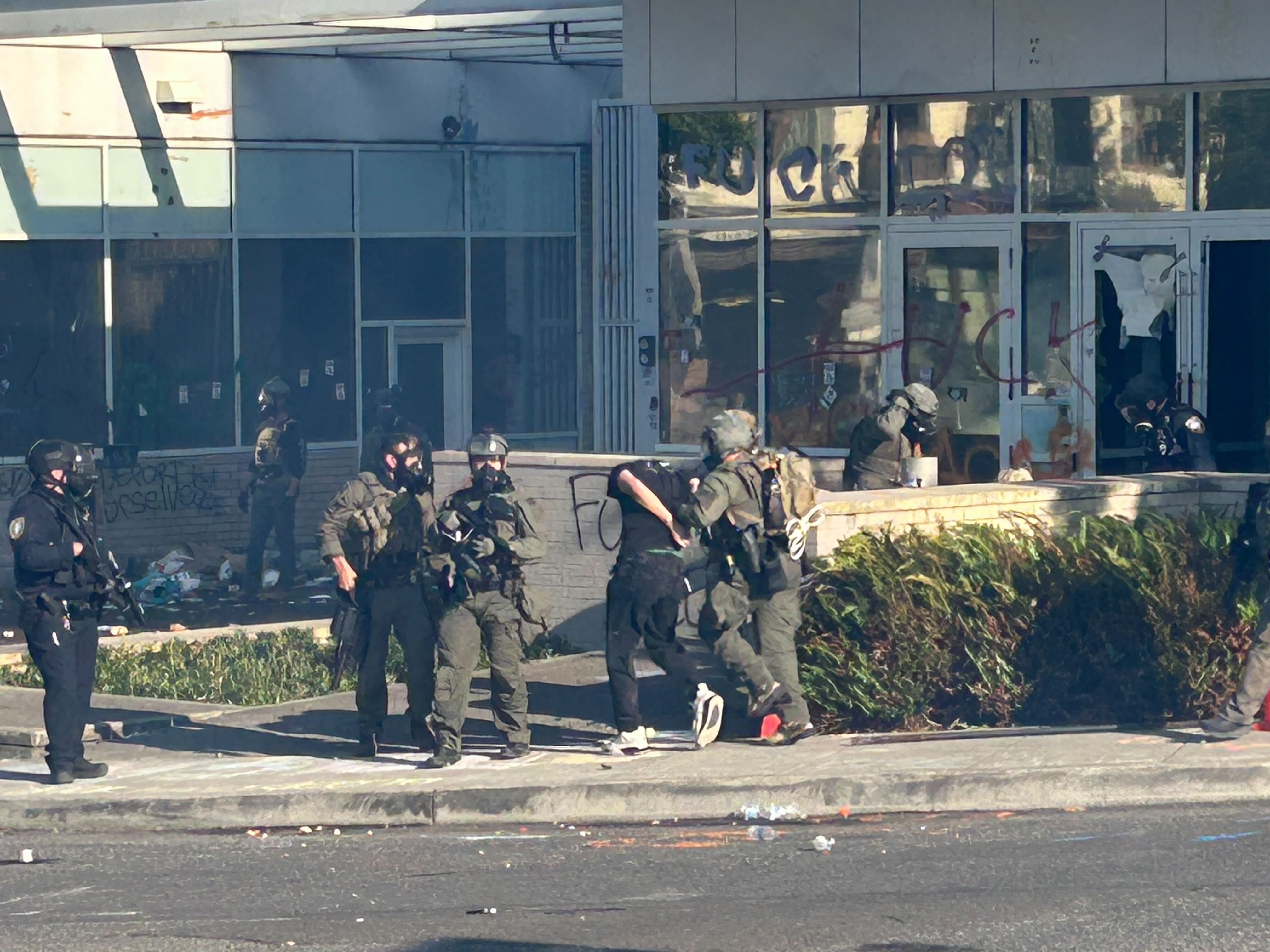 Federal officers arrest a protester outside the Portland ICE facility. Earlier on, a small group of demonstrators broke through the front door to the building.