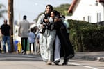 Two women cry as they leave a reunification center following the shooting at the Islamic Center of San Diego in southern California, on May 18, 2026. A shooting at the largest mosque complex in San Diego killed three people, with two suspected teenage gunmen later found dead in a car from self-inflicted gunshot wounds, police said.