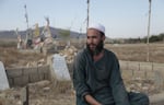 Ahmad Shah sits in the cemetery near his village of Patan Khel where his two brothers are buried. He said that when the Taliban took over Afghanistan last year, villagers saw divine intervention.