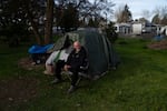 David Wilson sits outside his tent at Riverside Park on Thursday, March 21, 2024, in Grants Pass, Ore. The Oregon city's rules penalizing public camping were upheld by the Supreme Court this year.