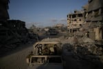 Israeli soldiers move next to destroyed buildings following Israeli strikes during a ground operation in the Gaza Strip on Friday, Sept. 13, 2024.