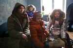 A woman and her three children sit in their Ukraine apartment, speaking to media about the war with Russia.