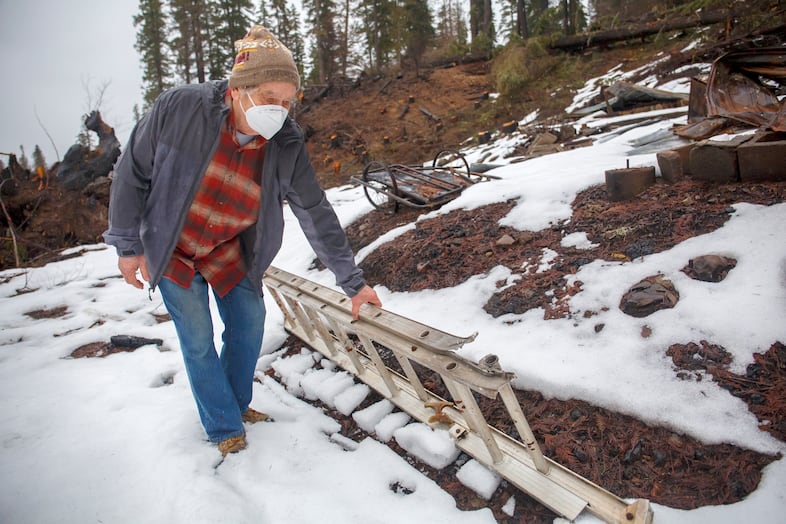 Jay Hennigan, president of the Breitenbush Cabin Owners Association, looks at some of the rubble remaining where his cabin once stood in Breitenbush, March 5, 2021. The cabin was destroyed by the Beachie Creek and Lionshead fires in 2020.