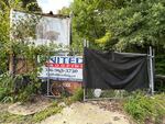 Signs from Ryan Routh’s old roofing business still hang on a storage area that he kept across the street from where he used to live in Greensboro, N.C. People in town say he used to house some of his workers in the trailer there.