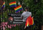 A National Park Service ranger places rainbow flags on the fence at the Stonewall National Monument in the West Village neighborhood of Greenwich Village in Lower Manhattan, New York City, on June 19, 2019.
