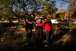 The Johnson family, whose home is one of the few that survived the Eaton Fire in their neighborhood in Altadena, Calif., prays with pastors outside their home Tuesday, Jan. 14, 2025. (AP Photo/Jae C. Hong)