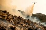 A helicopter drops water on the KNP Complex Fire burning along Generals Highway in Sequoia National Park, Calif., on Wednesday, Sept. 15, 2021. The blaze is burning near the Giant Forest, home to more than 2,000 giant sequoias.