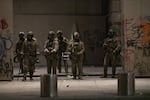 Federal officers in front of the Mark O. Hatfield federal courthouse in Portland, Ore., on July 12, 2020. Earlier in the night, federal law enforcement officers shot a demonstrator in the head with a less lethal impact munition, causing severe injury.