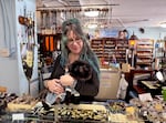 Front-of-store manager Mercy Crowe with her dog Winnie at the front desk of Love Potion Magickal Perfumerie & Marketplace in Vancouver, Wash., on Sept. 26, 2026.