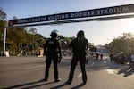 Police officers stand guard as they close the gate of the main entrance of Dodger Stadium on Thursday.