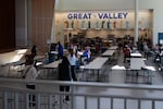 Sixth-grade students — some standing, some sitting — arrive in the cafeteria at the Great Valley 5/6 Center in Malvern, Pennsylvania, on February 2. The cafeteria has rows of tables with attached benches.