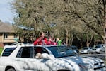 Elmonica counselor Alexis Mason rides past her students during a parade Sunday.