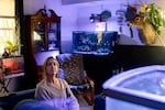 Becca Morris sits surrounded by fish tanks and plants, in the public housing apartment where she’s lived with her son for nine years, in Bridgeville, Delaware on Wednesday, May 14, 2025. (Wesley Lapointe/ for NPR)