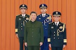 In this photo released by Xinhua News Agency, Chinese President Xi Jinping, bottom left, who is also Chairman of the Central Military Commission (CMC) poses for photos with newly promoted generals Zhang Shuguang, top left and Wang Gang, top right while Zhang Shengmin, Vice Chairman of the CMC stands at the right in Beijing, on Friday, July 3, 2026.